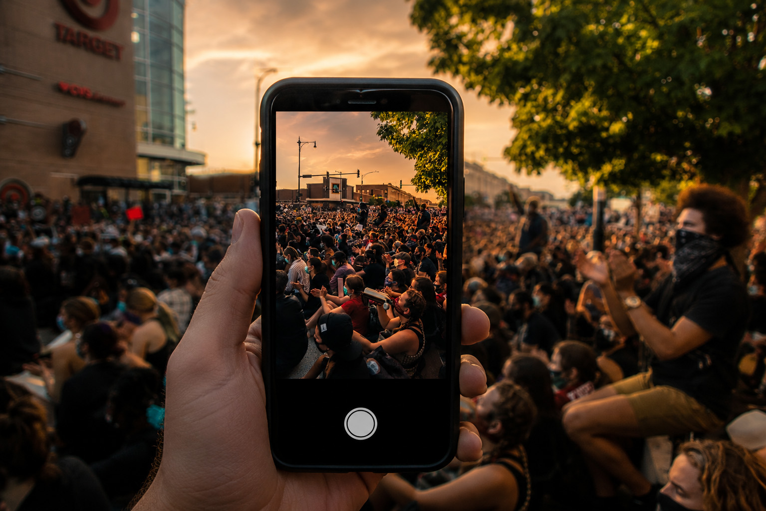Phone capturing a protest at sunset